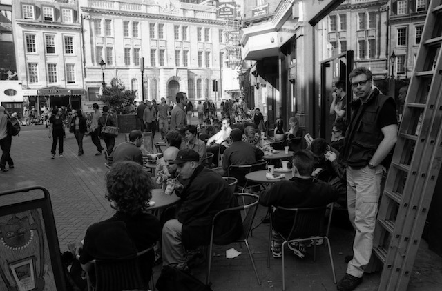 Street café with a man standing beside the tables