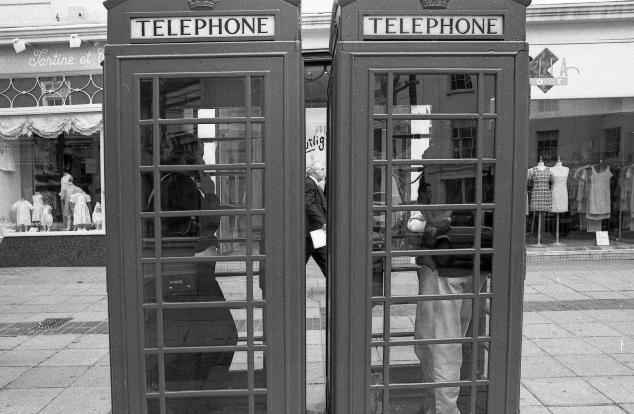 Two telephone booths with people inside